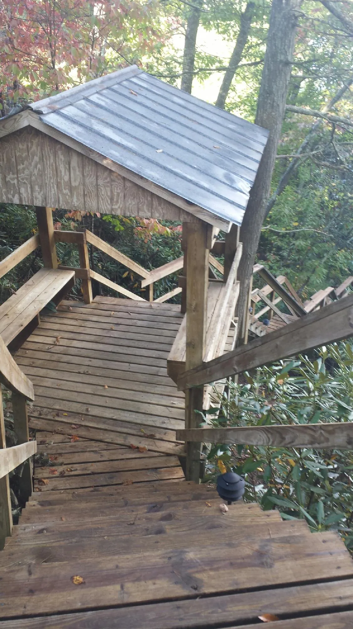 Metal roofed shelter over wooden steps on a wooded walkway — Skylight Repair & Installation work by our crew in Unionville